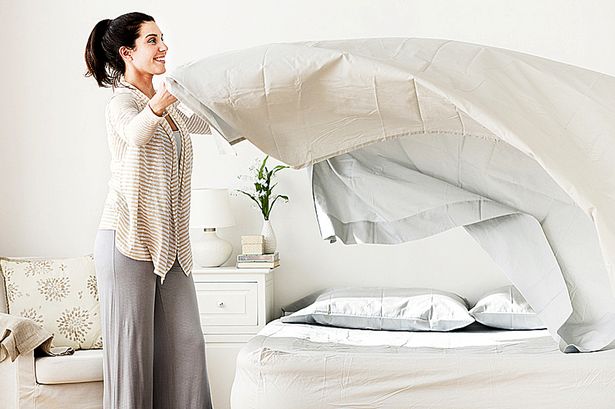 Woman changing bedsheets